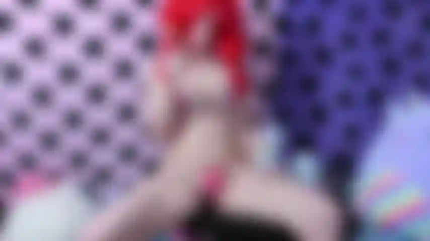 Masturbo carina con un dildo in corno di unicorno color pastello in un bikini a cuore e una parrucca rossa mentre lecco un lecca-lecca colorato.