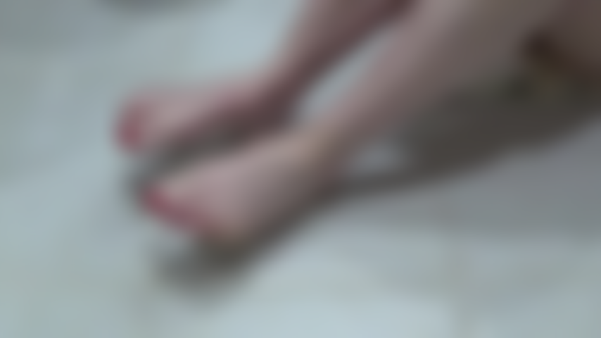 Il piede a piedi nudi prende in giro le unghie dei piedi dipinte di rosso a piedi nudi.