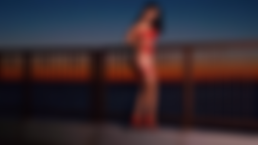Sensuale provocazione in topless sulla spiaggia all'alba.