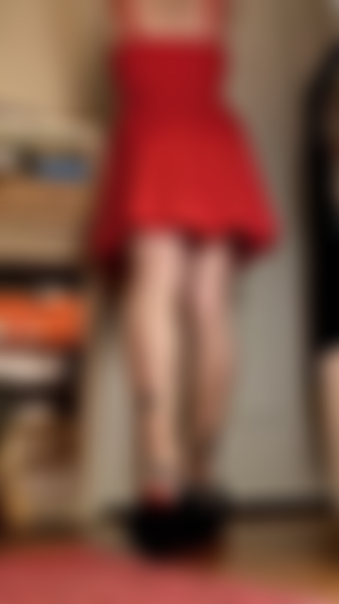 Le gambe lunghe del vestito rosso si piegano, le suole mostrano.