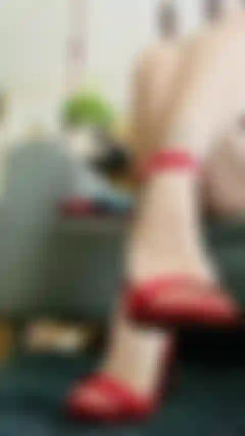 Stiletto in vernice rossa penzolante, piedi da milf.