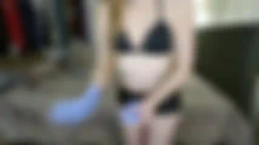 Pantaloncini neri lucidi, guanti da esame viola e ascelle pelose (non nuda).