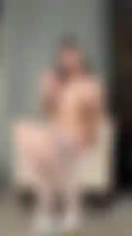 Che allarga le gambe indossando calze bianche e tacchi.