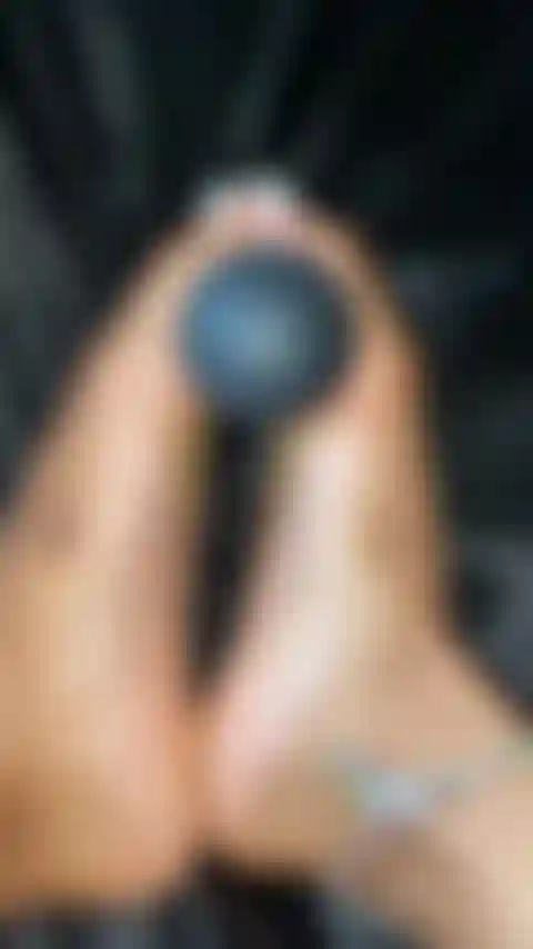 Le dita dei piedi piuttosto bianche giocano con il giocattolo.