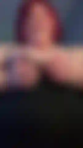 Canottiera con massaggio alle tette e capelli rossi.