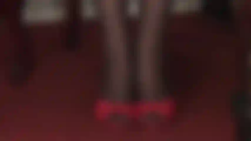 Seduzione con tacchi alti e calze: le ciabatte rosse sexy con tacchi alti e i collant neri con cuciture a motivo floreale sono pura seduzione.