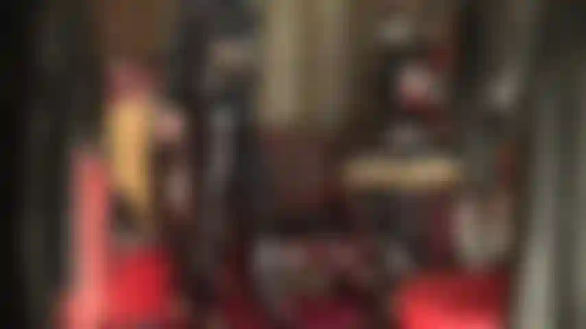 Feticista del pvc: vestita completamente in vinile nero lucido, la padrona stuzzica la feticista del pvc con jeans lucidi, tacchi e lungo cappotto.