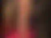 Indosso calze di nylon vintage con cuciture color carne e giarrettiere, scarpe con tacco alto sexy, un enorme strapon bianco e un lungo cappotto di pelle nera.