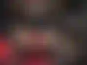 Indosso guanti di pelle rossa su un enorme strap-on nero.