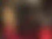 Una padrona bionda in una tuta attillata e lucida in pvc.