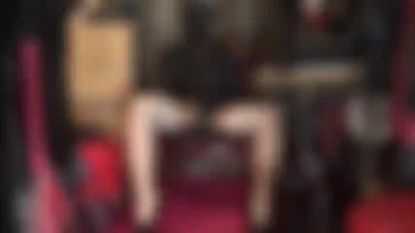 Che accarezza 2 enormi dildo neri: cappuccio in spandex con occhi aperti, cappello in pelle da padrona, guanti in lattice, calze e collant lucidi.