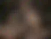 Una dea della pelle che indossa occhiali sexy e accarezza il suo enorme strapon bianco.