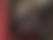 Una padrona vestita con una tuta di vinile nero lucido, con delle cinghie su uno dei suoi enormi cazzi, uno spesso strap-on bianco, che spinge e sculaccia.