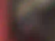 Una padrona vestita con una tuta di vinile nero lucido, con delle cinghie su uno dei suoi enormi cazzi, uno spesso strap-on bianco, che spinge e sculaccia.