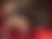 Vista laterale di gambe sexy in calze con cuciture e giarrettiere con tacchi penzolanti.