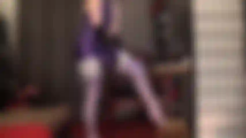 Dominatrice con strap-on in una sexy tuta in spandex viola leohex e calze bianche: così tanta lucentezza ti fa girare la testa e ti fa venire voglia di scopare.