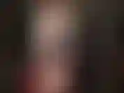 Una padrona con un cappotto di pelle bianca, un vestito di vinile rosso e collant, che indossa uno dei suoi grandi strapon bianchi per farti sbavare.