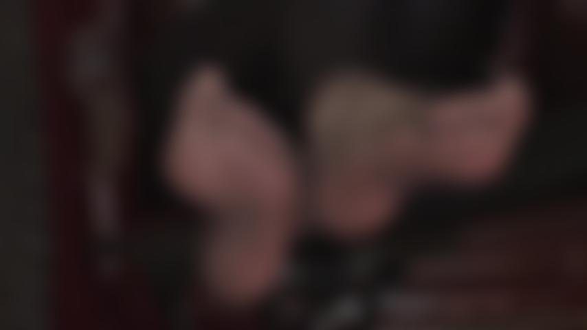 Con caviglie incrociate, suole morbide e dita dei piedi sexy in nylon setoso: i piedi velati e neri della padrona stuzzicano l'amante dei piedi.