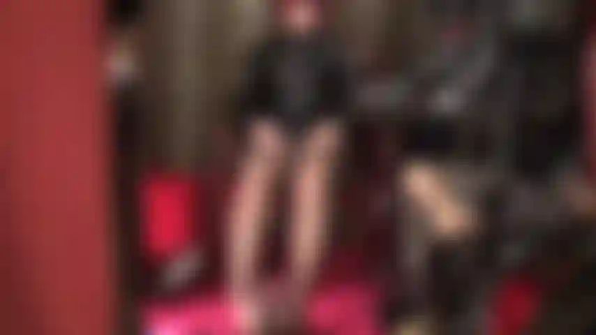 La padrona accarezza due cazzi: è vestita in pvc lucido e collant marroni, i suoi piedi sono avvolti attorno al cazzo nero mentre la padrona accarezza il suo strap-on bianco a mani nude.