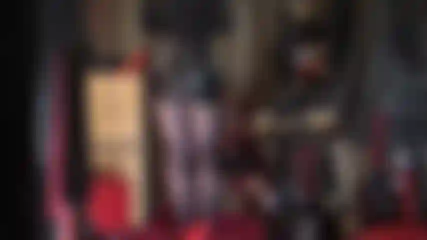 Con una gonna di pelle sexy e collant lucidi blu scuro.