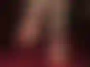 Feticista dei piedi nudi, con tacchi a spillo rossi e cinturino alla caviglia, penzolanti.