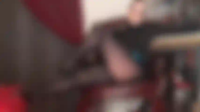 La padrona seduce con le sue gambe in collant neri lucidi e una scollatura sexy in reggiseno di pizzo.