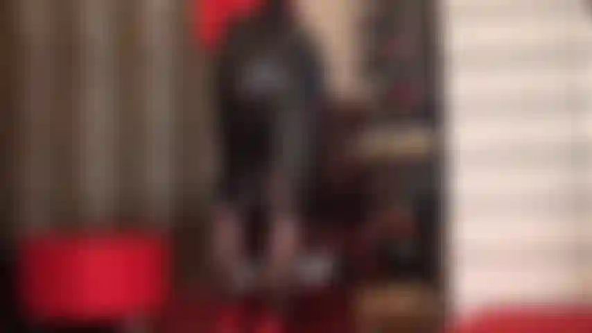 Un'adoratrice del culo con una gonna a tubino in pelle nera e collant neri.