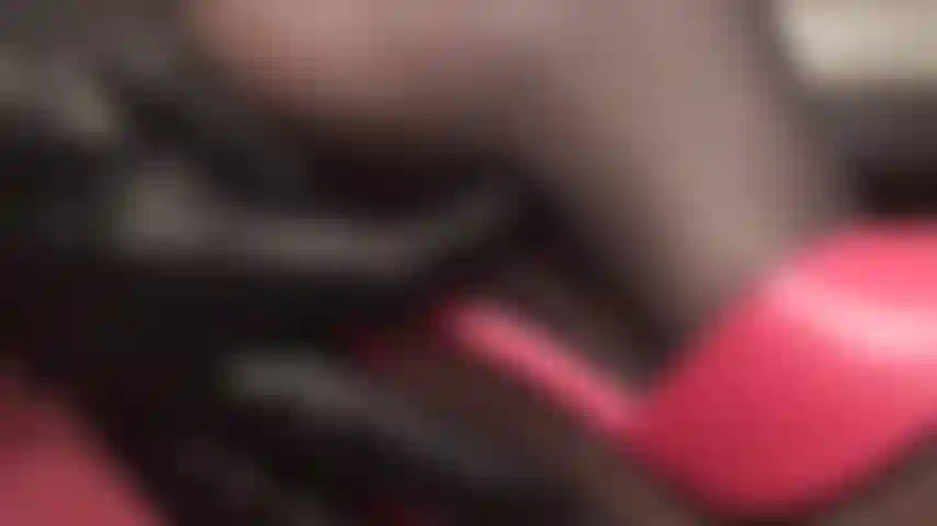 Da vicino e personale con i tacchi della padrona e i piedi in calze di nylon nere e mules rosse.