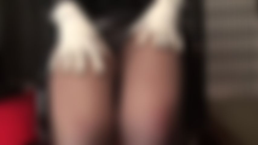 Provocazione in bianco e nero: graziosi tacchi bianchi con cinturino alla caviglia, guanti bianchi e body bianco contrastano con il pvc nero lucido. Provocazione della padrona con viste sotto la gonna e gambe in collant color caffè.