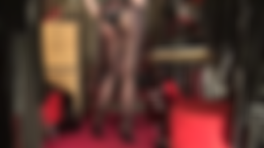 Gambe da urlo, vestita con collant neri trasparenti e setosi, piedi in un paio di sexy sabot in pelle con tacco alto e una tuta in lattice lucido per completare il look irresistibile.