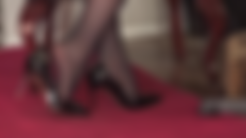 Con stiletti lucidi in vernice nera e strati di nylon.