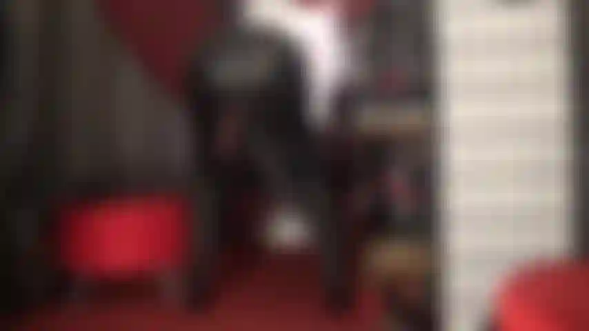 Ti provoca con il suo enorme cazzo nero che penzola dalla gonna di pelle.