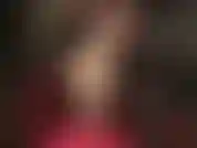 Che mostra lunghe gambe indossando collant color carne e décolleté rosse con tacco in acciaio.