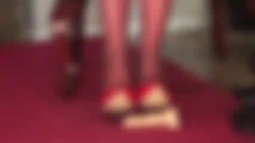 Con scarpe rosse lucide, collant ai piedi e frustino per tormentare il tuo cazzo da schiavo.