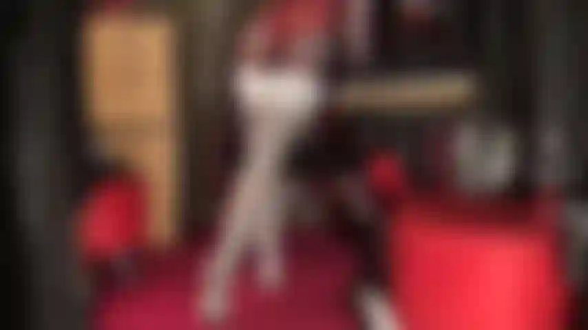 Calze bianche lucide sopra i collant, stivali neri alti e pantaloncini di raso blu lucido.