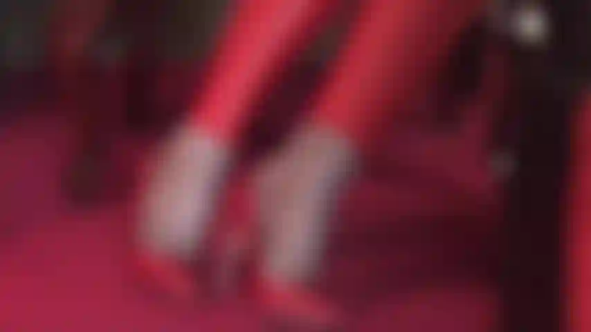 Con collant che stuzzicano i piedi, décolleté in pelle rossa e leggings coordinati.