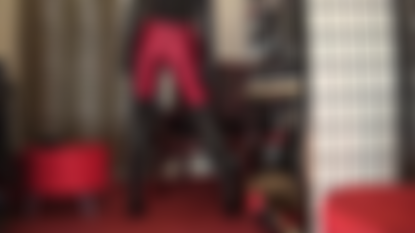 Con un outfit fetish in rosso e nero: adorazione del culo con collant lucidi in spandex rosso scuro, stivali in pelle sopra il ginocchio, lunghi guanti in pelle e, infine, pantaloncini attillati in lycra a vita alta.