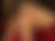 Sexy, con le gambe incrociate in nylon color carne e le décolleté rosse lucide.