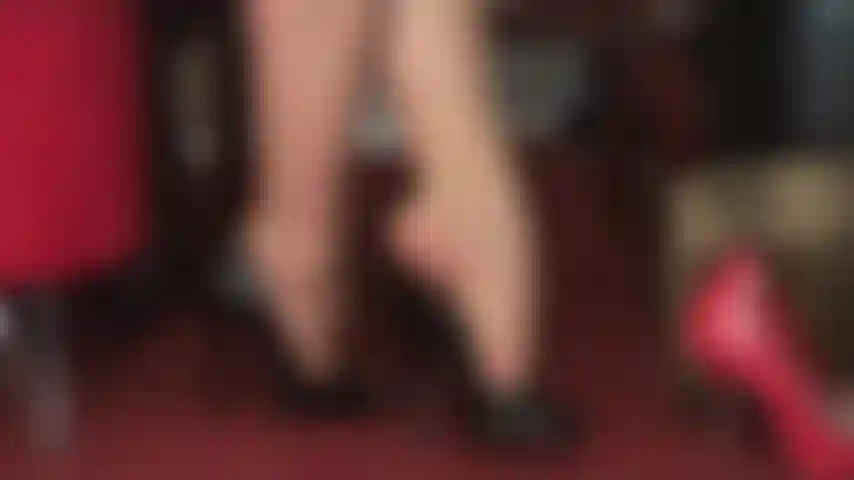 Feticista dei piedi, adoratrice dei tacchi alti, penzolante: bellissime peeptoe nere e lucide pendono dalle dita dei collant della padrona.