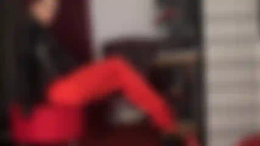 Gambe e scollatura: gambe lente e sensuali che stuzzicano con collant in lycra rosso acceso e seducenti cerniere che stuzzicano la tuta della padrona.