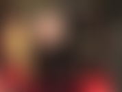 Uno sguardo sotto la sexy gonna nera in vinile della padrona rivela collant neri trasparenti e stivali alti e lucidi.