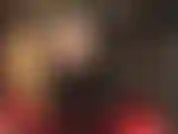 Uno sguardo sotto la sexy gonna nera in vinile della padrona rivela collant neri trasparenti e stivali alti e lucidi.