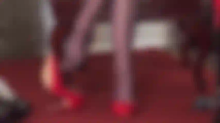 La padrona vivian mette in mostra le sue abilità con un paio di scarpe rosse lucide e collant lucidi marrone scuro, con la frusta in mano.