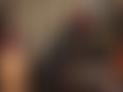 Una dea del lattice in una tuta attillata di gomma che si fa lubrificare il suo strapon nero per il duro pegging che ti meriti.