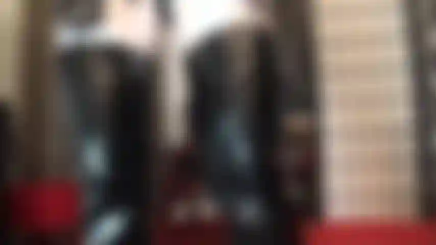 Con un outfit fetish in bianco e nero, stivali e guanti in pvc lucido abbinati a collant in lycra bianca lucida.