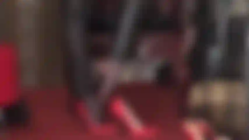 Feticista dei piedi e adoratrice dei tacchi alti: pantaloni di pelle, tacchi a spillo rossi e collant per stuzzicare i piedi.