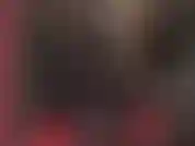 Una dea fetish del lattice perversa, in tuta di gomma nera con cappuccio e strapon bbc.