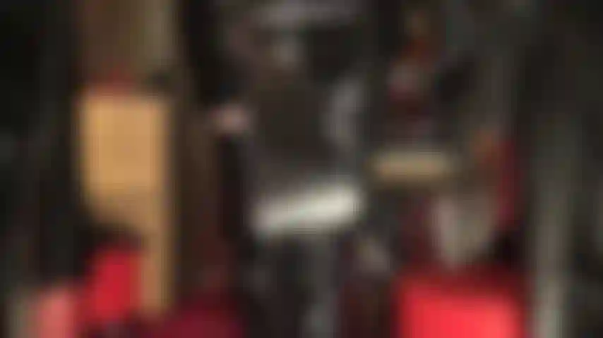 Una mistress fetish in pvc lucido con frustino e stivali sopra il ginocchio.