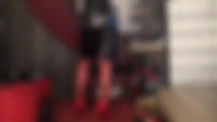 Calze rosse, tacchi e gonna in vinile nero lucido.