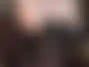 Sensuale ed erotica, con spalle, ascelle e scollatura scoperte, in corsetto di pelle nera, gambe e collant neri semi-opachi.